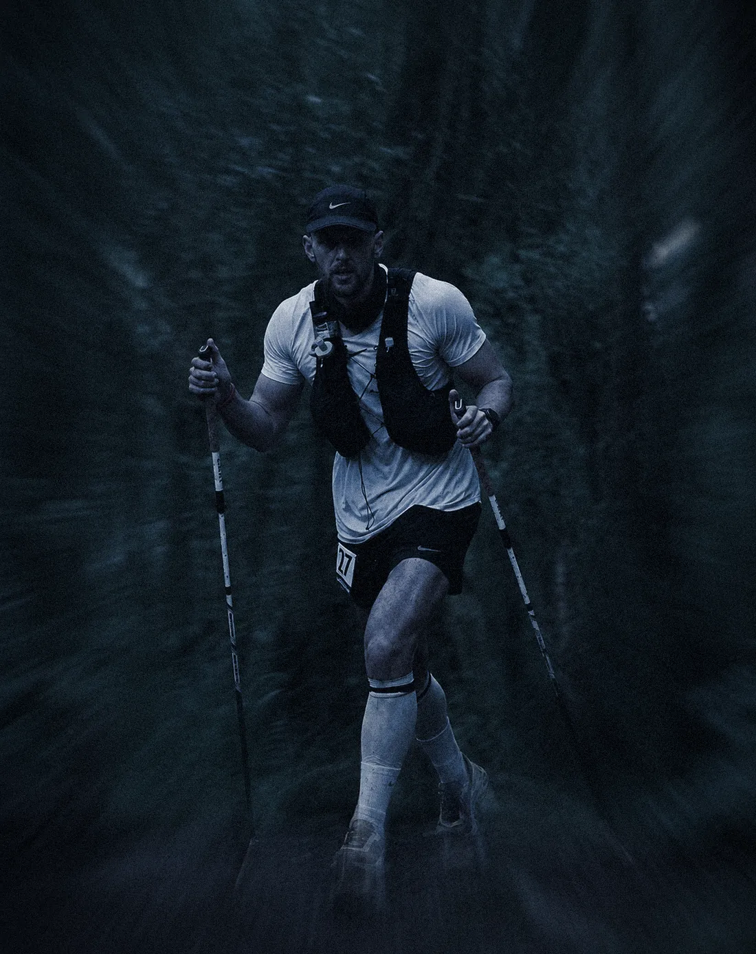 Flavien running with poles on a forest trail during Ultra X Tanzania